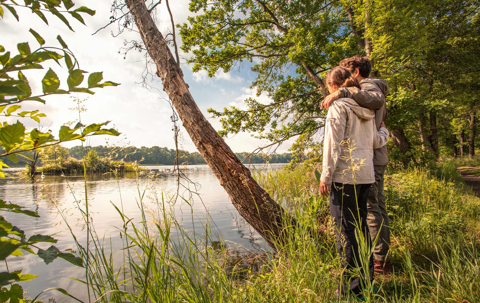 Paar steht beim Wandern Arm in Arm am Ufer der Elbe